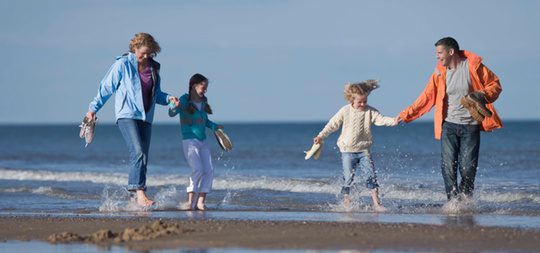 Una familia paseando por la playa